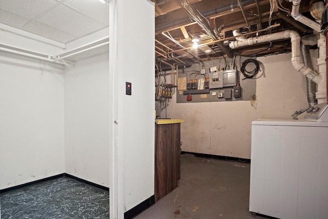 unfinished basement featuring baseboards and washer / dryer