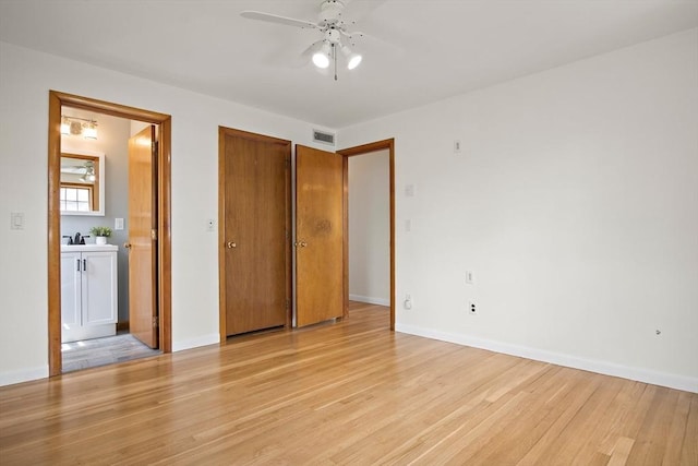 unfurnished bedroom with a sink, ensuite bathroom, visible vents, light wood-style flooring, and baseboards