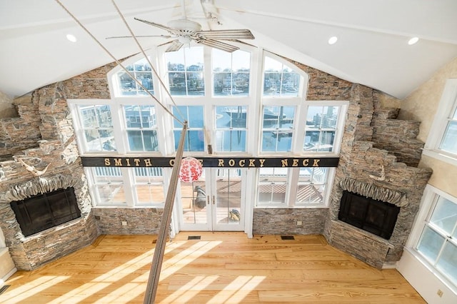 unfurnished living room with wood finished floors, vaulted ceiling, and a fireplace