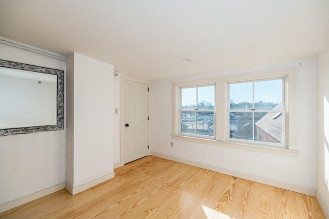 unfurnished room with baseboards and wood finished floors