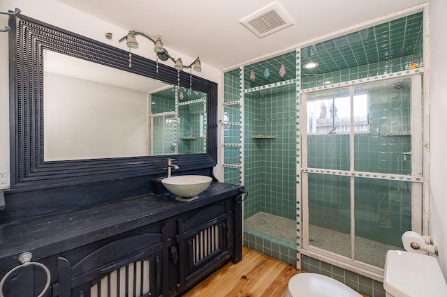 full bath with vanity, a stall shower, toilet, visible vents, and wood finished floors