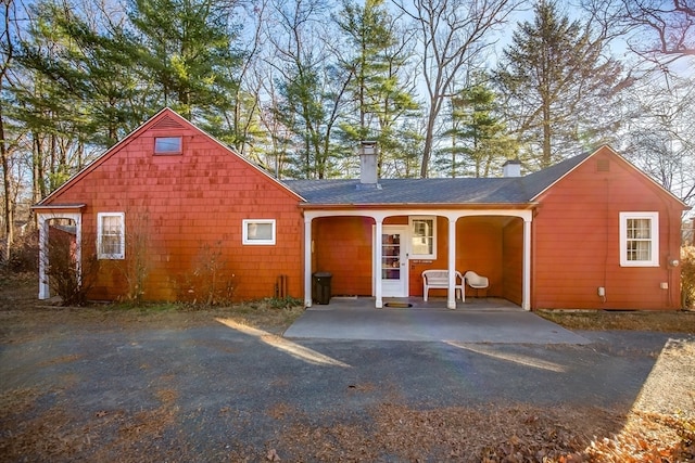 back of property featuring covered porch