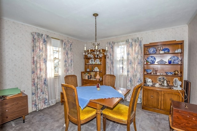 carpeted dining space featuring ornamental molding, a wealth of natural light, and a notable chandelier