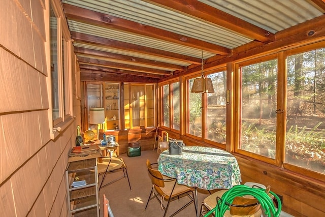 sunroom / solarium featuring beamed ceiling