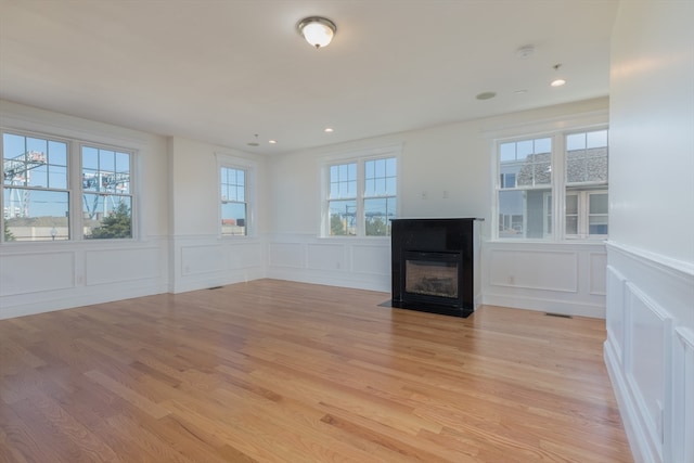 unfurnished living room with a wealth of natural light and light wood-type flooring