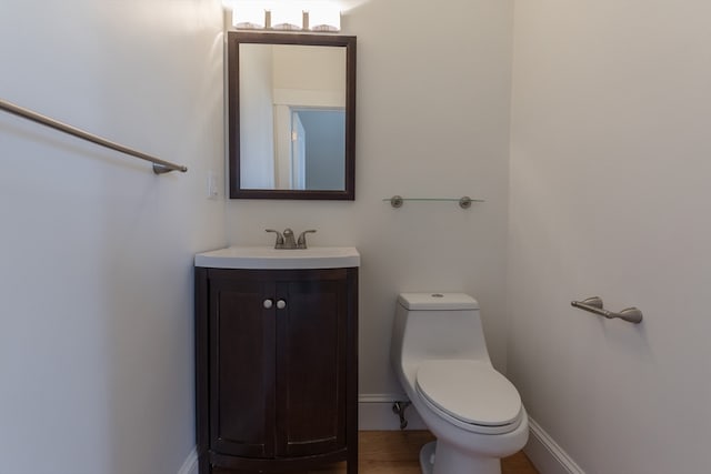 bathroom with vanity, toilet, and hardwood / wood-style flooring