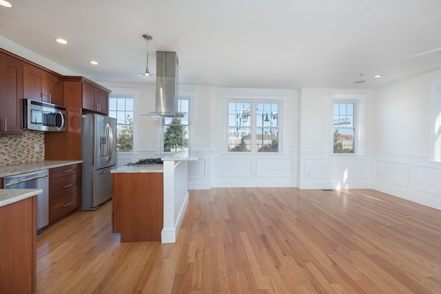 kitchen with a healthy amount of sunlight, light hardwood / wood-style floors, stainless steel appliances, and pendant lighting