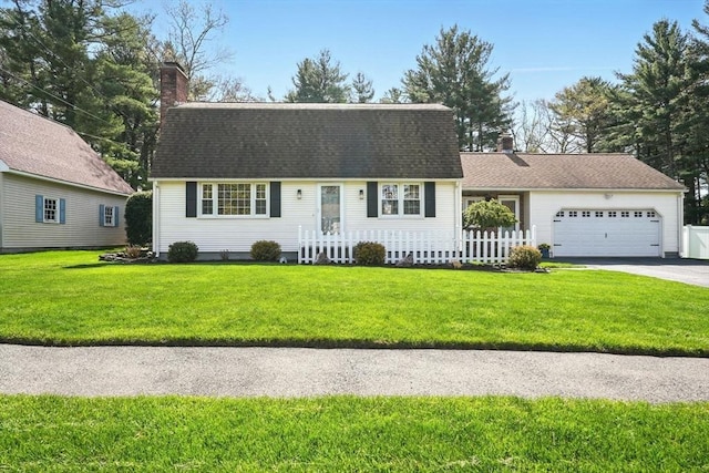 view of front of house with an attached garage, a chimney, a front lawn, and aphalt driveway