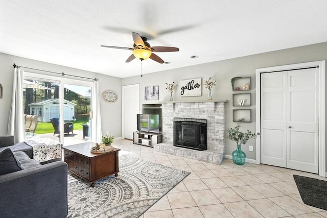 living room with baseboards, a ceiling fan, light tile patterned flooring, and a fireplace