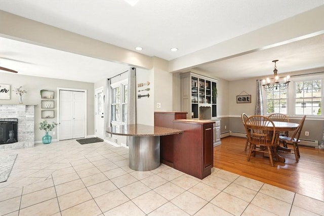 kitchen featuring plenty of natural light, a baseboard radiator, an inviting chandelier, and light tile patterned flooring