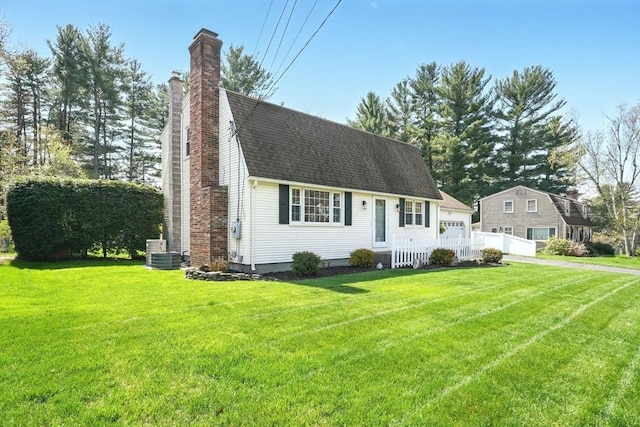 view of front of house featuring a garage, roof with shingles, a front yard, and a chimney