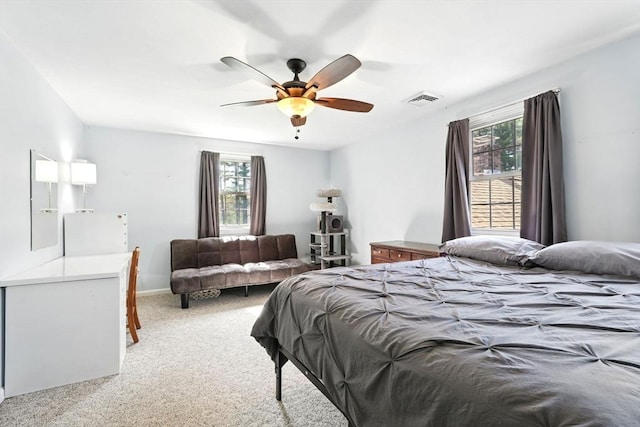 bedroom with a ceiling fan, visible vents, and light carpet