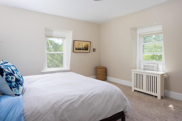 carpeted bedroom with radiator, cooling unit, and baseboards