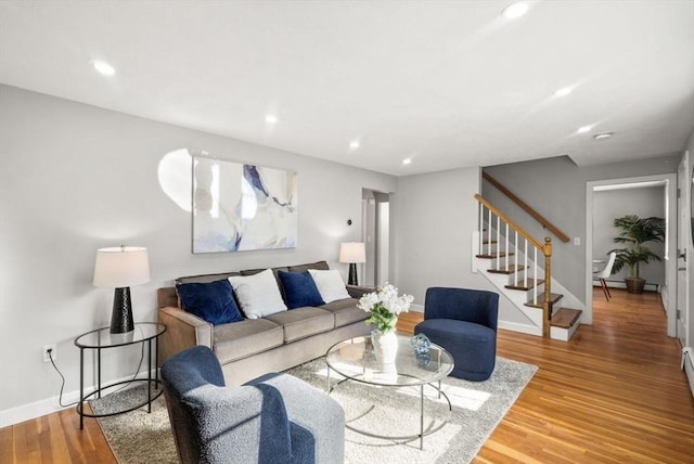 living room featuring recessed lighting, stairway, baseboards, and wood finished floors