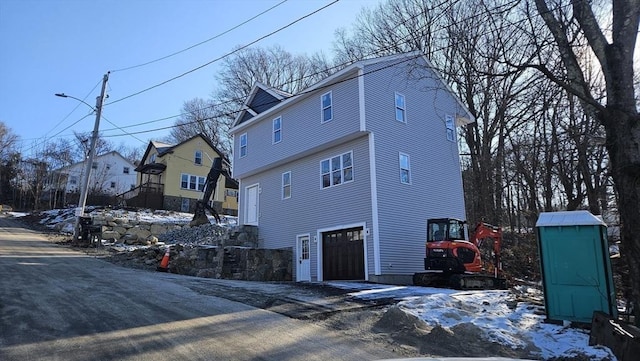 view of snowy exterior with a garage