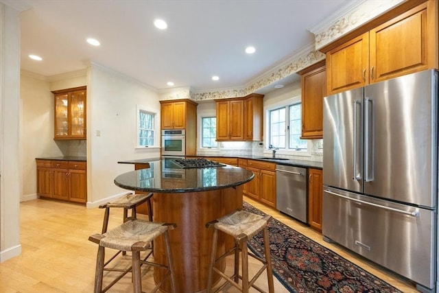 83 High Ridge Rd, Boxford, MA 01921 - kitchen with appliances with stainless steel finishes, brown cabinetry, ornamental molding, a kitchen breakfast bar, and decorative backsplash