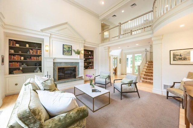 83 High Ridge Rd, Boxford, MA 01921 - living area featuring ornate columns, crown molding, a towering ceiling, a premium fireplace, and built in shelves