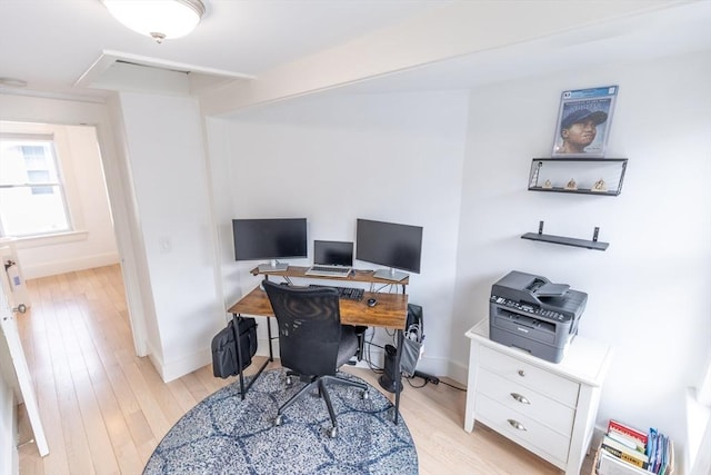 office space with baseboards and light wood-type flooring