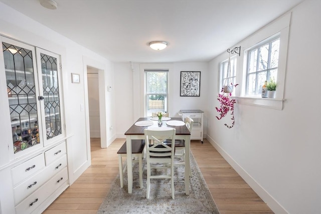 dining area with light wood-style floors and baseboards