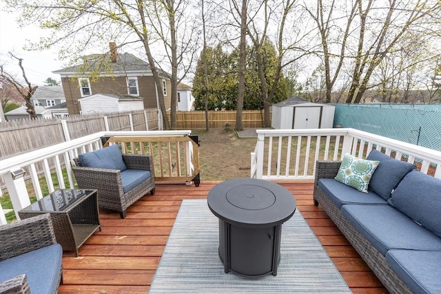 deck featuring a storage shed, an outdoor living space, an outbuilding, and a fenced backyard