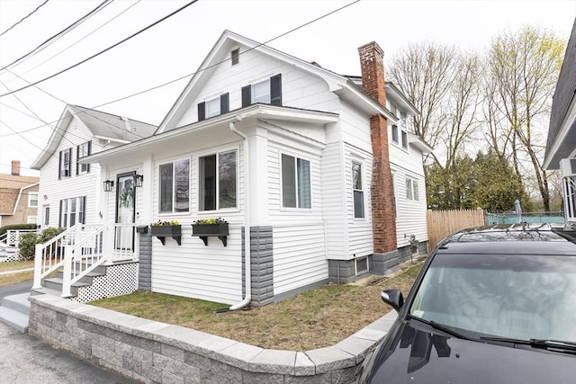 view of front of house featuring fence and a chimney