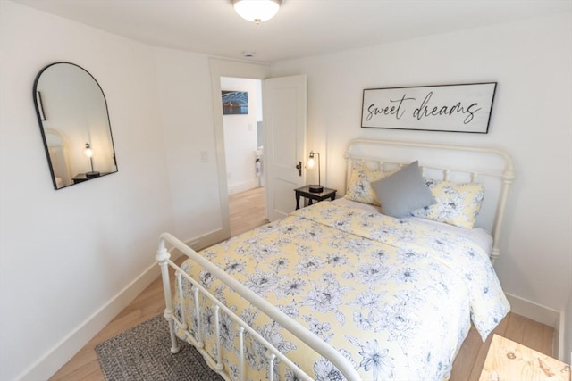 bedroom featuring baseboards and wood finished floors