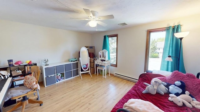 bedroom featuring a baseboard radiator, light wood-style flooring, and ceiling fan