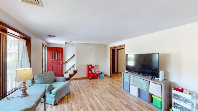 living area with light wood finished floors, stairs, and baseboards