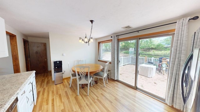 dining area with a chandelier, light wood finished floors, and baseboards