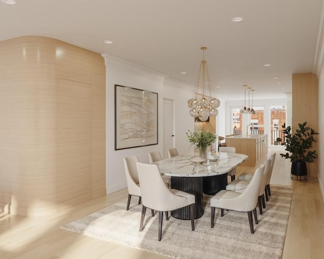 dining space with light wood finished floors, ornamental molding, and recessed lighting