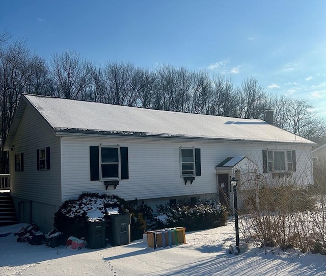 view of snow covered back of property