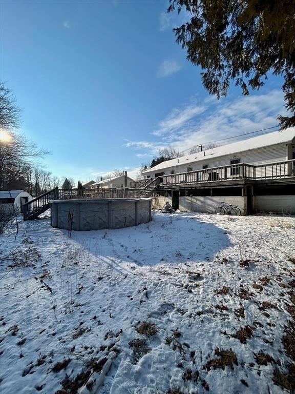 yard layered in snow with a swimming pool side deck