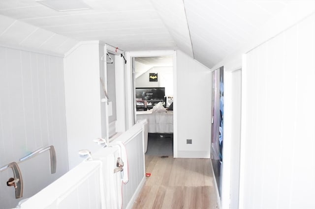 hallway with light hardwood / wood-style flooring and lofted ceiling