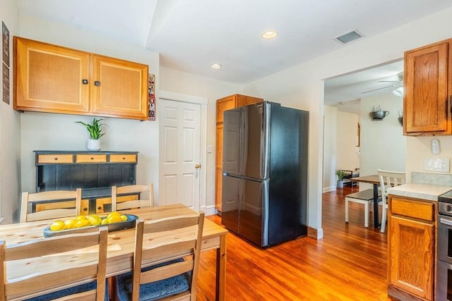 kitchen featuring freestanding refrigerator, wood finished floors, recessed lighting, light countertops, and stainless steel electric stove