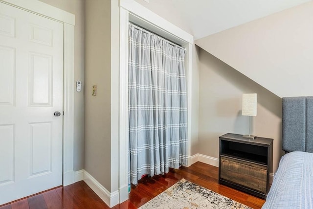 bedroom with dark wood-style floors and baseboards