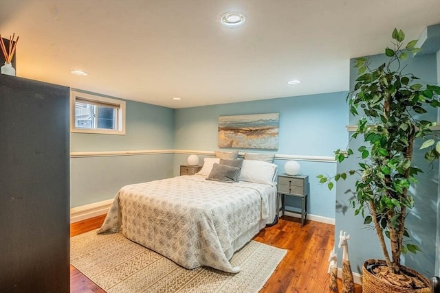 bedroom featuring wood finished floors, baseboards, and recessed lighting