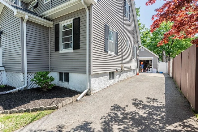 view of home's exterior with fence and a detached garage