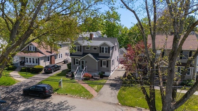view of front of home featuring a chimney and a front lawn