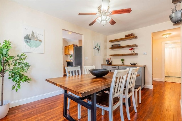 dining room featuring a ceiling fan, wood finished floors, and baseboards