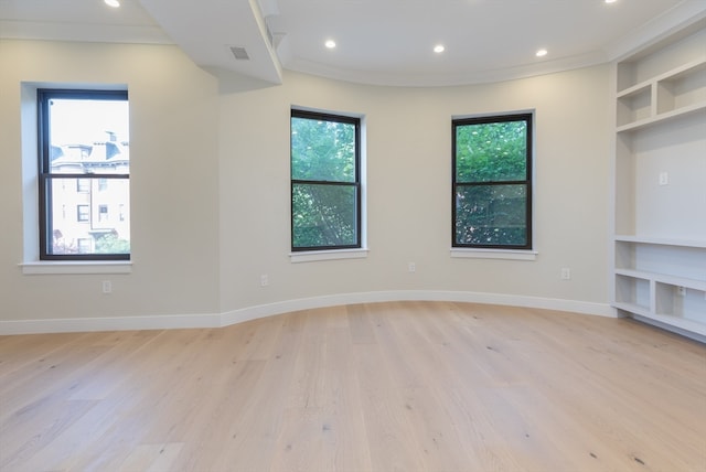 unfurnished living room featuring light hardwood / wood-style floors and ornamental molding