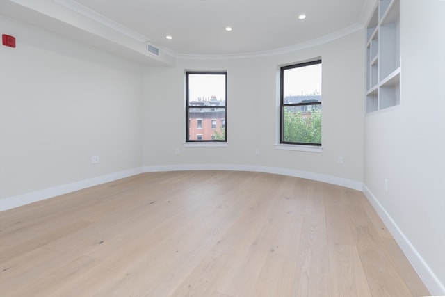 unfurnished room featuring crown molding and light wood-type flooring