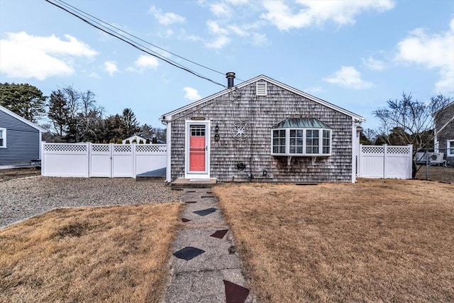 view of front of house featuring a front lawn and fence