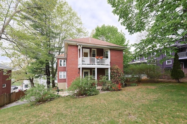 back of property featuring brick siding and a balcony