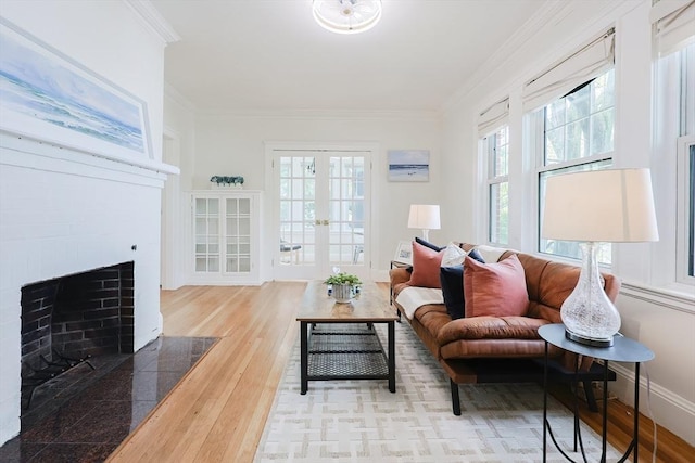 living area featuring ornamental molding, wood finished floors, and a fireplace