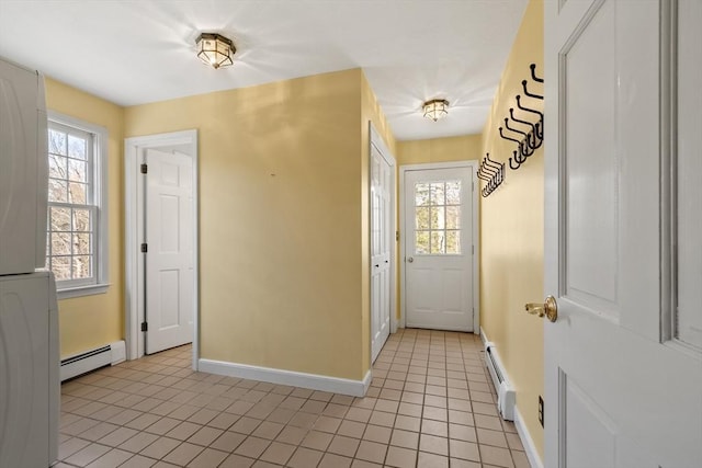 foyer featuring baseboard heating, plenty of natural light, light tile patterned floors, and a baseboard radiator