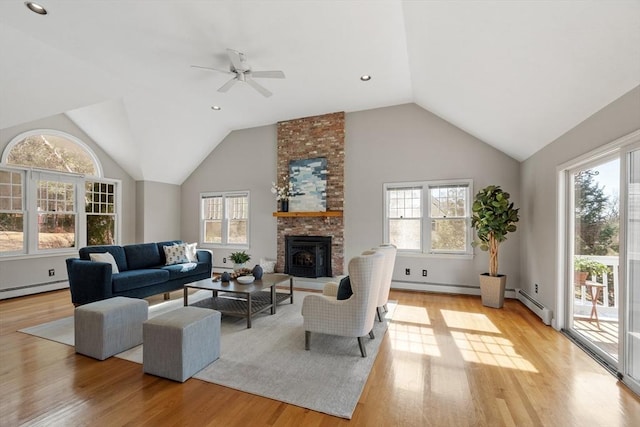 living area featuring a brick fireplace, a baseboard heating unit, lofted ceiling, recessed lighting, and light wood-style flooring