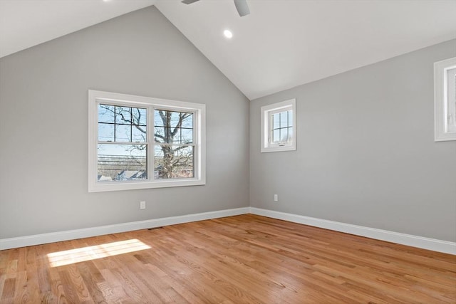 empty room with ceiling fan, high vaulted ceiling, and light wood-type flooring