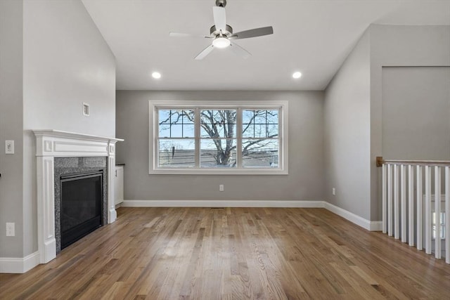 unfurnished living room with hardwood / wood-style flooring, ceiling fan, and a fireplace