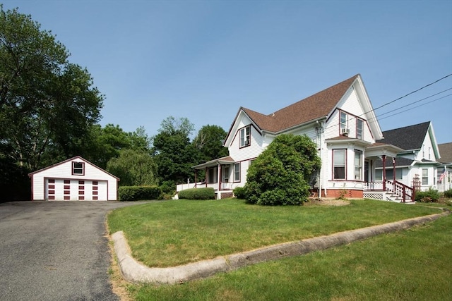 18 Morton St, Brockton, MA 02301 - view of home's exterior featuring a porch, a detached garage, an outbuilding, and a lawn