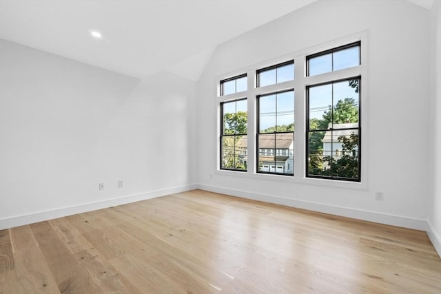 empty room featuring lofted ceiling and light hardwood / wood-style floors